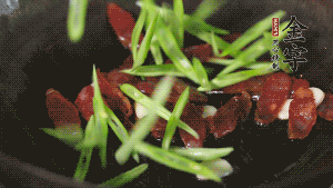 先后下香腸片、四季豆絲均勻翻炒，加適量清水燜煮一下。