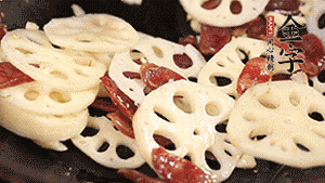 依次下香腸片、藕片翻炒均勻，加適量清水燜熟。