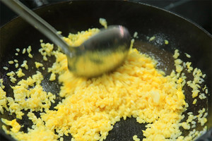 大火加熱炒鍋，再入油，燒到四至五成熱時(shí)倒入雞蛋液，在未凝結(jié)之前，加米飯煸炒，不停翻炒并用鍋鏟將成塊的米飯碾開、撥散。