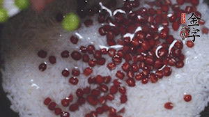 將炒好的食材和大米、紅豆一起放進(jìn)電飯鍋煮。