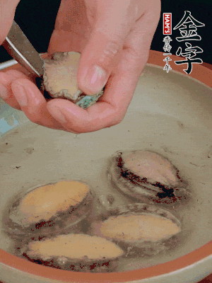 鮑魚加鹽、清水浸泡，用勺子挖出鮑魚肉。