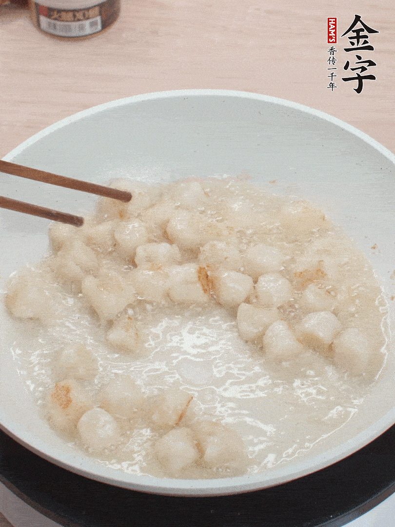 油溫4成熱，鮮貝蘸干淀粉下鍋煎，一面微黃后翻面。