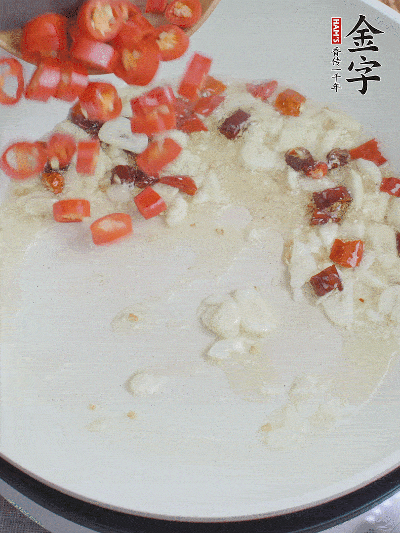 油6成熱，下蒜末、干紅辣椒煸炒，出香味后再放美人椒、香腸。