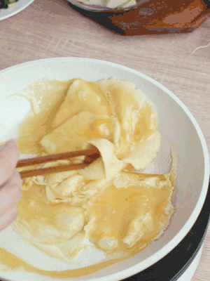 油6成熱時(shí)，下雞蛋液，邊緣凝固時(shí)翻拌成塊狀。