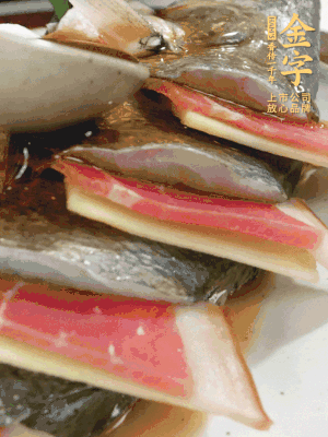 魚肚中塞蔥結(jié)、火腿片，魚身上碼放姜片、火腿片，倒入混合的料汁。