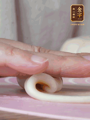 做面劑 油皮按扁，中間包入一個油酥，邊緣收緊捏死。包好的面劑按扁，用搟面杖搟壓成橢圓形。從底部向上卷成筒狀，用保鮮膜蓋好松弛15分鐘，再把筒狀縱向搟壓成長條狀。再卷一次，松弛20分鐘