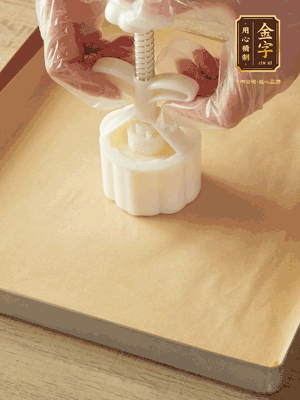 取一個(gè)面團(tuán)，捏扁，中間厚，四周薄。虎口往上推，直到收口，把餅胚放入模具里，壓2-3下