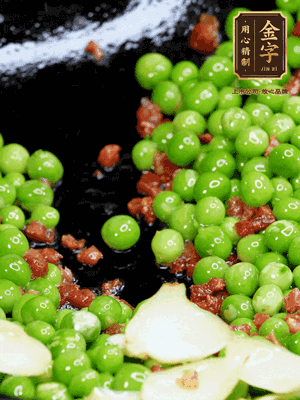 鍋內(nèi)少許油，下火腿煸香，再下甜豆米、百合翻炒，少許鹽、一點水煮到收干